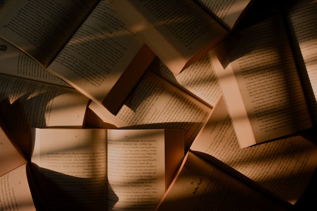 Pile of books spread around in shadows.